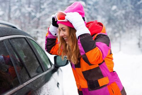 kobieta obok samochodu wybiera się na narty